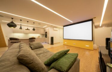 Panorama of elegant designed living room with soft couch, light color walls